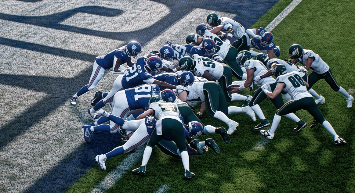 American Football Spieler in blauen und weißen Trikots kämpfen um den Ball im Gras.