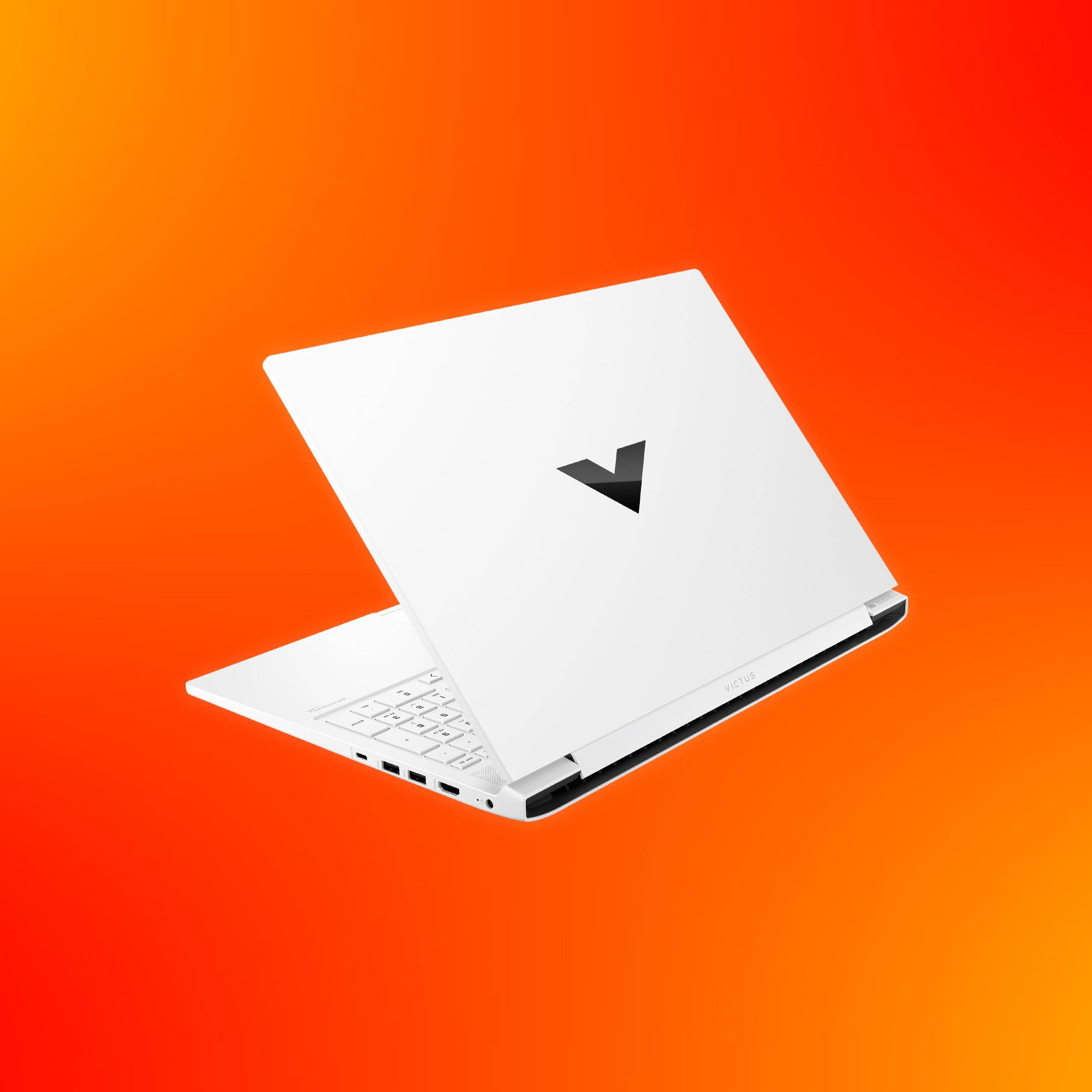 Biały laptop z czarnym logo V na pokrywie, na tle gradientu pomarańczowo-czerwonego.