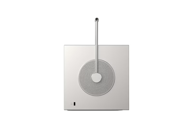 Un altavoz plateado con rejilla circular y asa.
