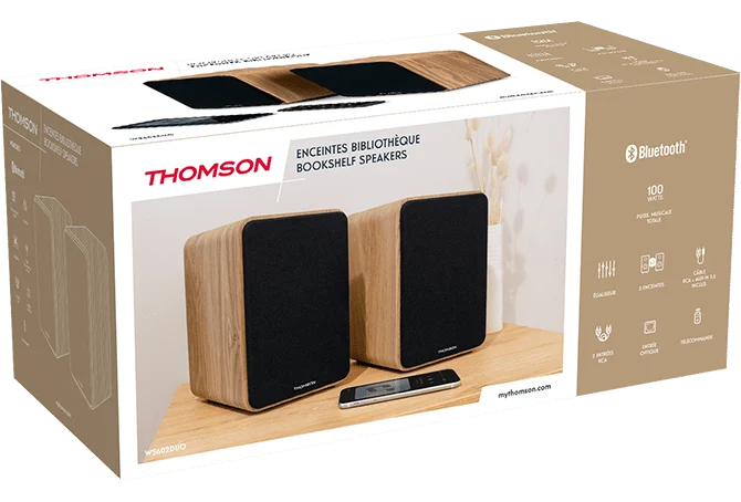 Altavoces Thomson con acabado de madera y mando a distancia sobre mesa.