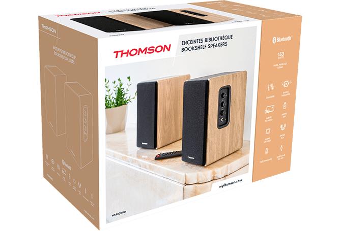 Caja con dos altavoces de madera, mando a distancia y planta.