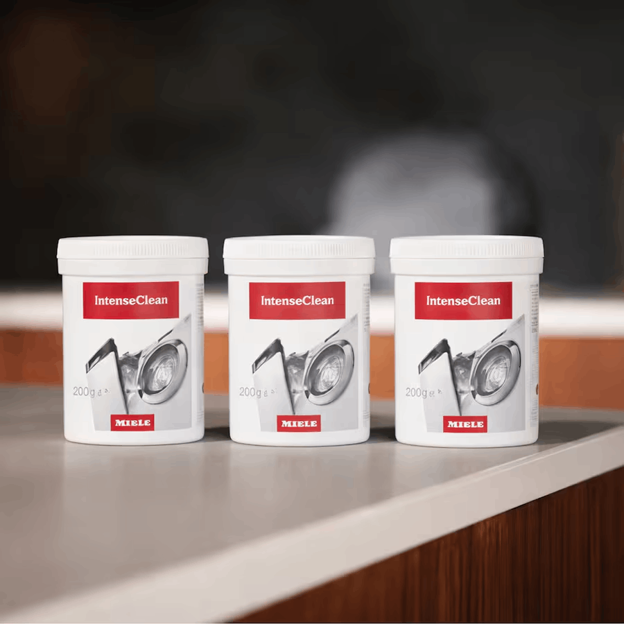 Tres recipientes blancos Miele IntenseClean con imágenes de puertas de lavadora.