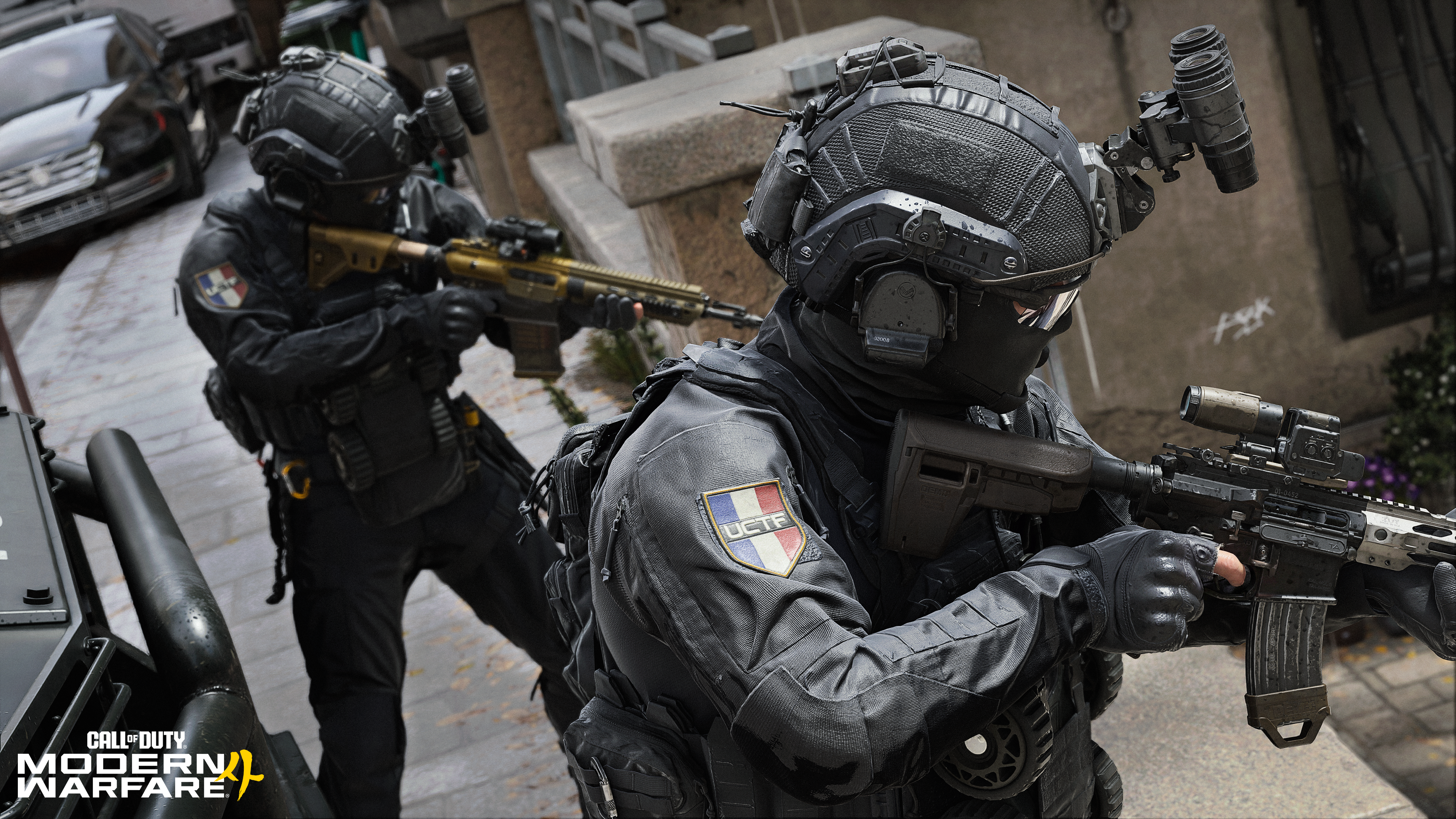 Deux soldats en noir, casqués et armés, dans un environnement urbain.