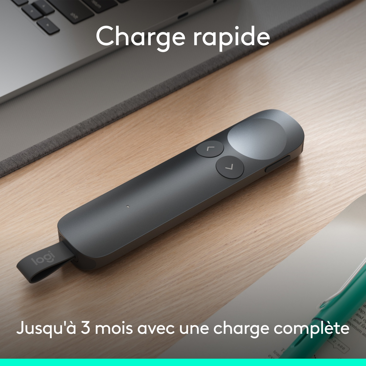 Pointeur Logitech gris à deux boutons, sur un bureau en bois.