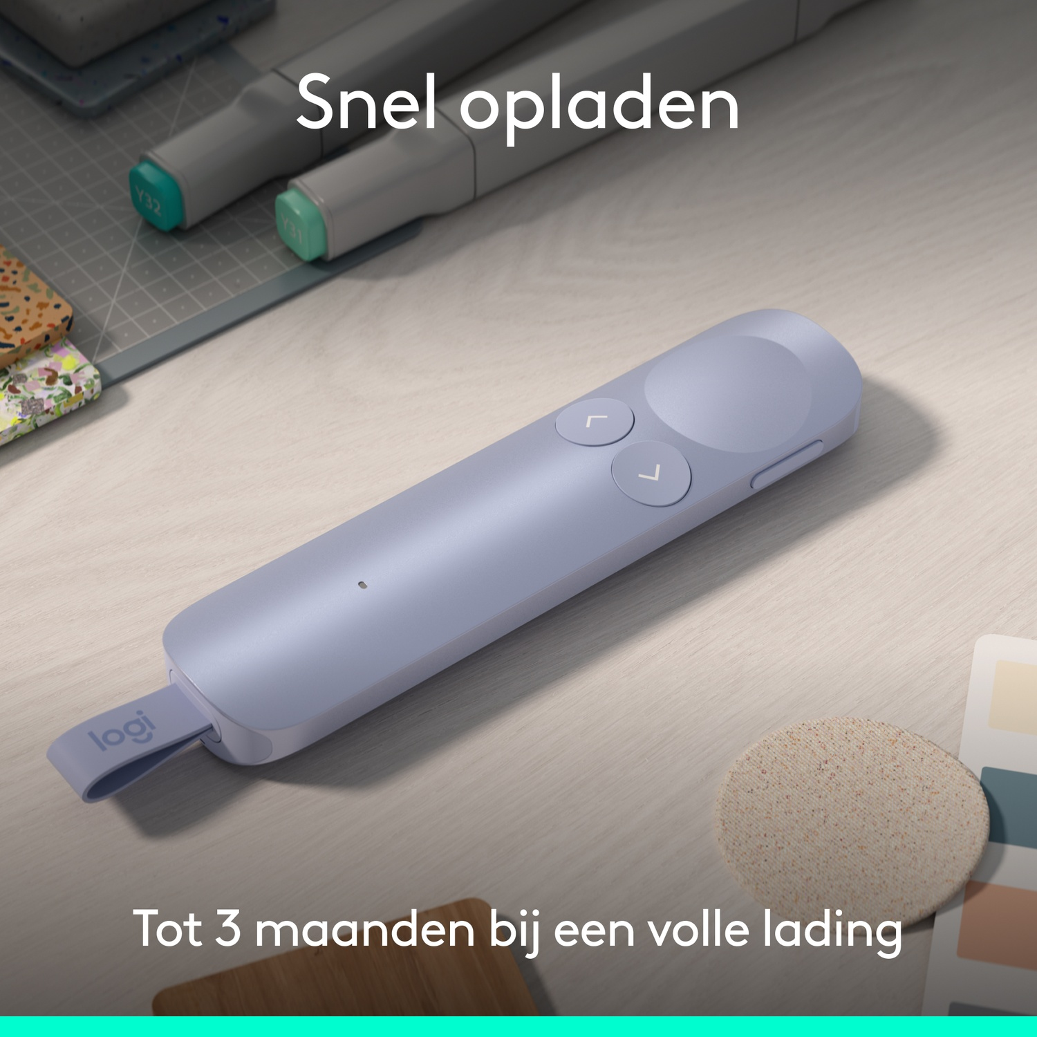Een paarse Logitech presenter ligt op een houten bureau naast stiften.