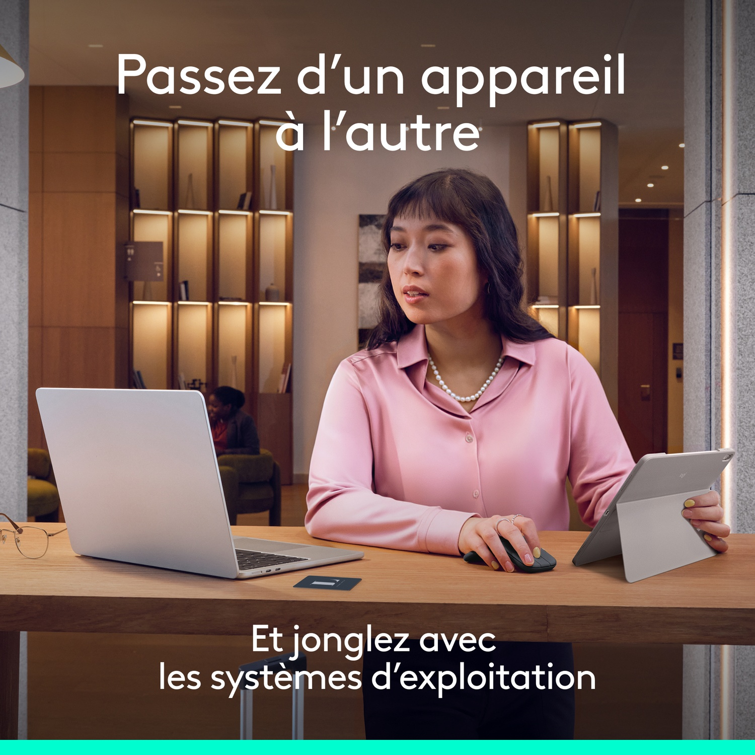 Une femme utilise un ordinateur portable, une souris et une tablette à un bureau.