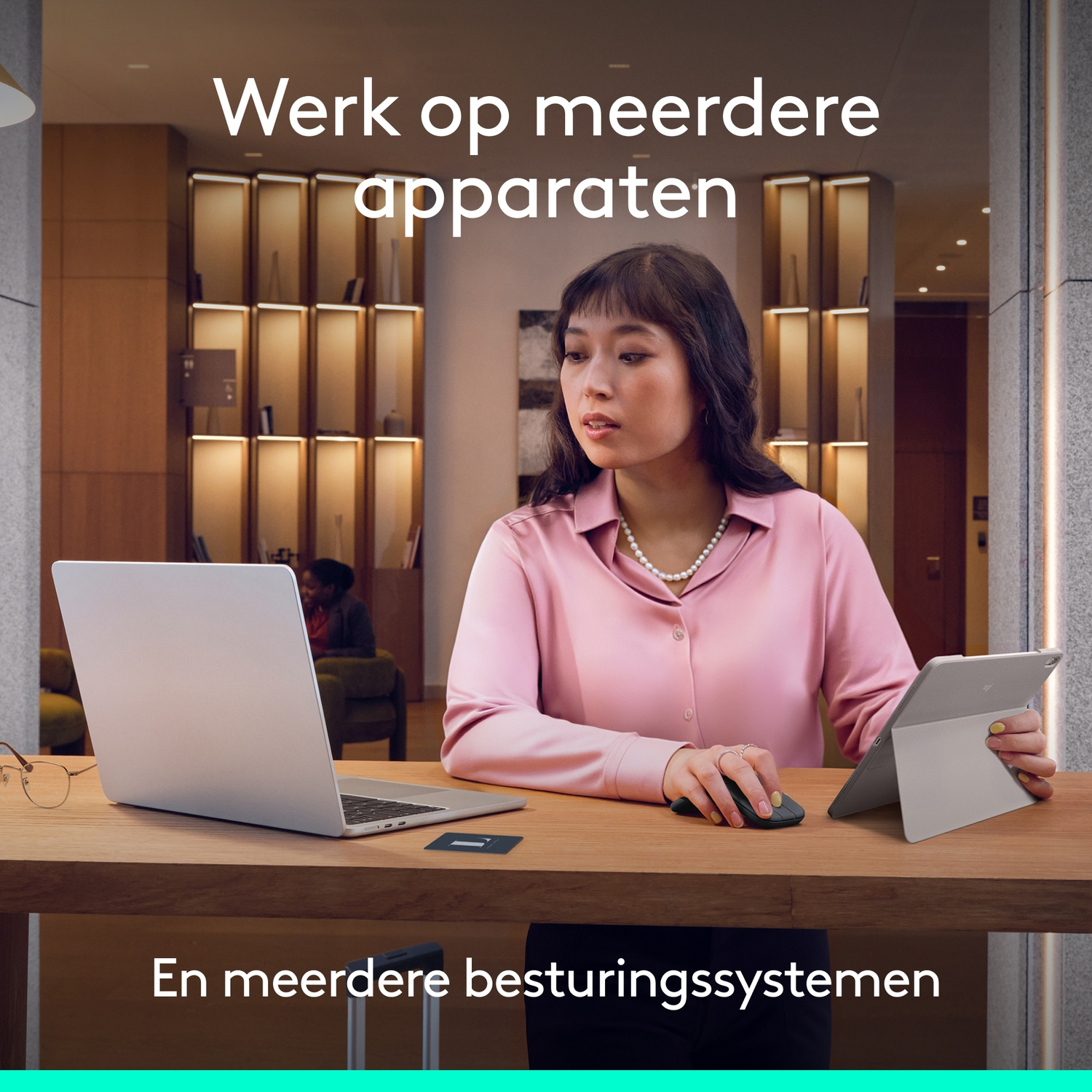 Vrouw werkt op laptop en tablet met muis en bril op tafel.