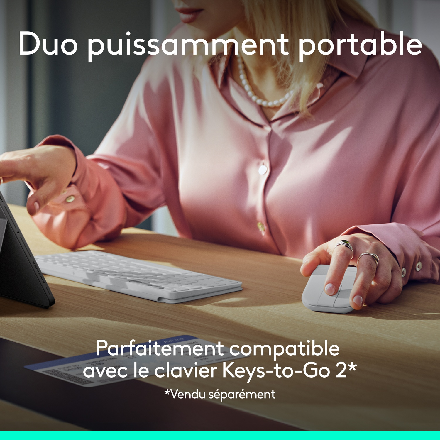 Femme avec souris et clavier sur bureau en bois. Tablette à gauche.
