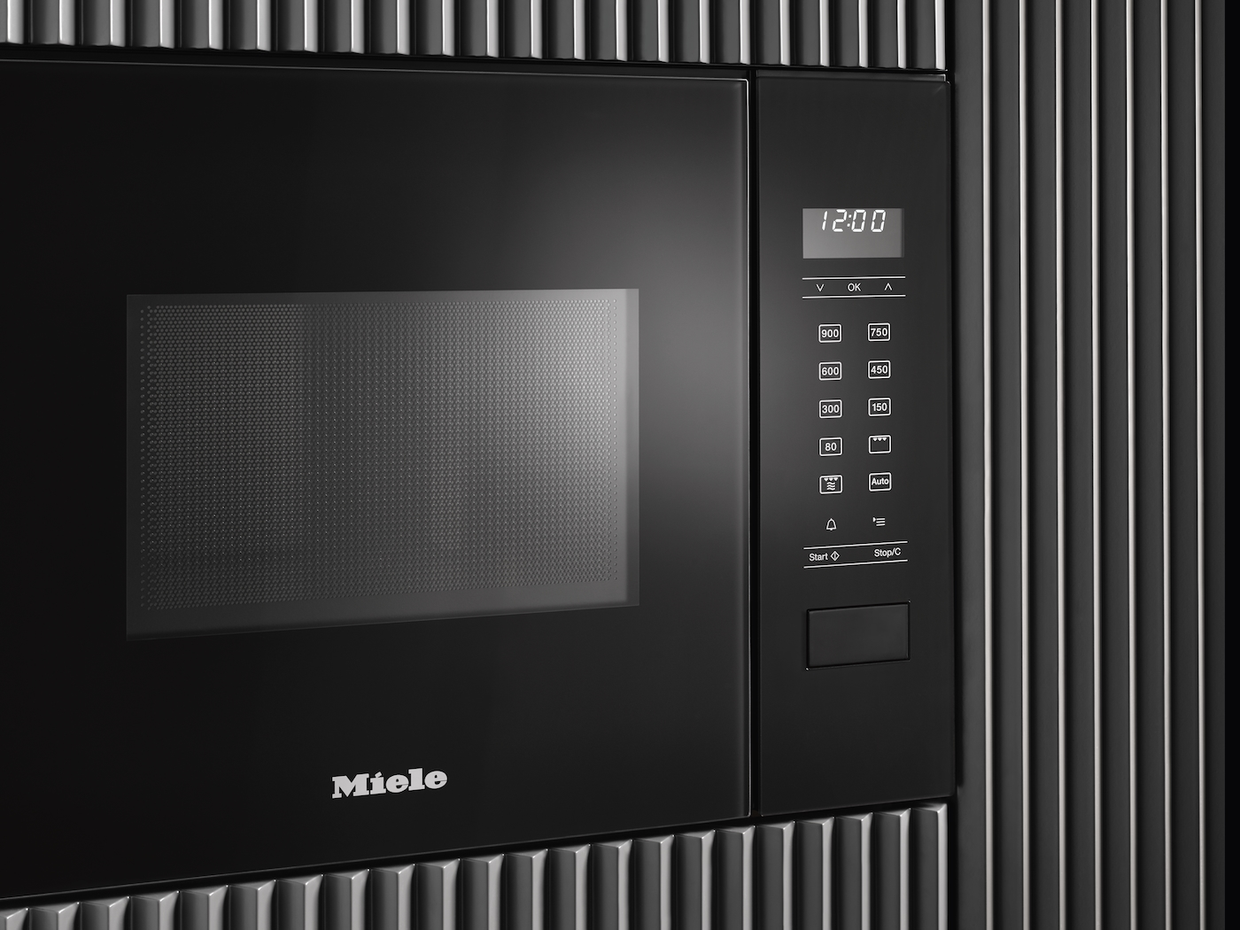 Eine schwarze Miele Mikrowelle mit digitaler Anzeige und Tasten.