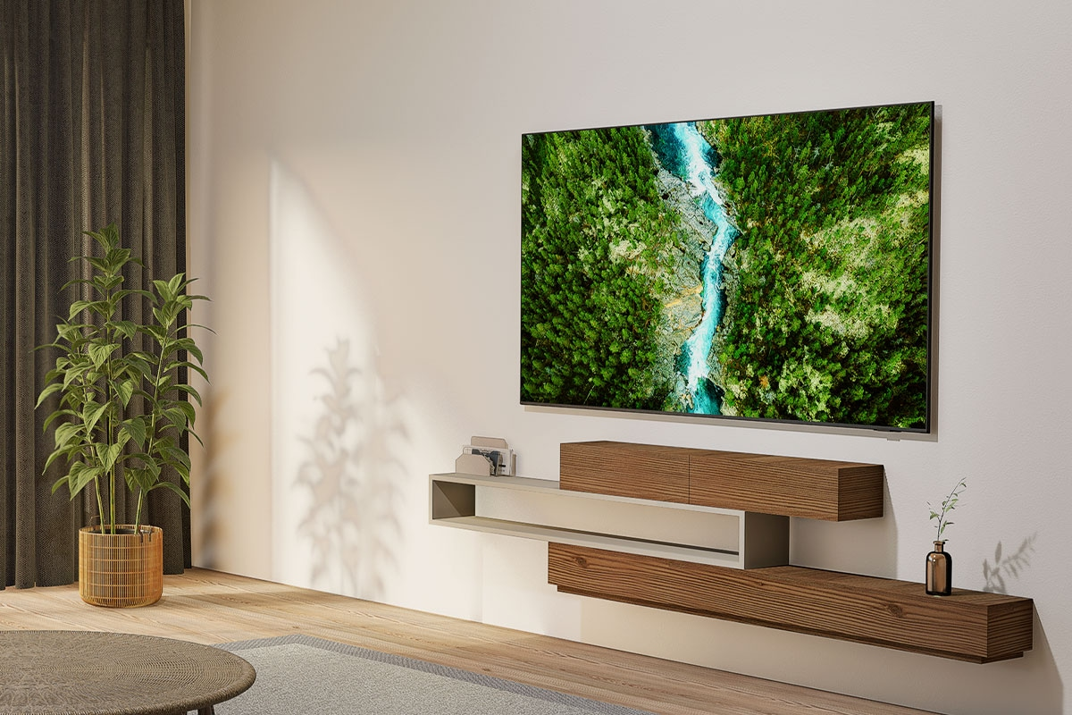 Duży telewizor z krajobrazem rzeki wisi nad drewnianą półką.