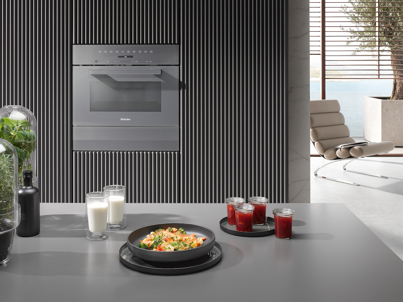 Moderne Küche mit Miele-Ofen, Essen und Getränken, Blick aufs Meer.