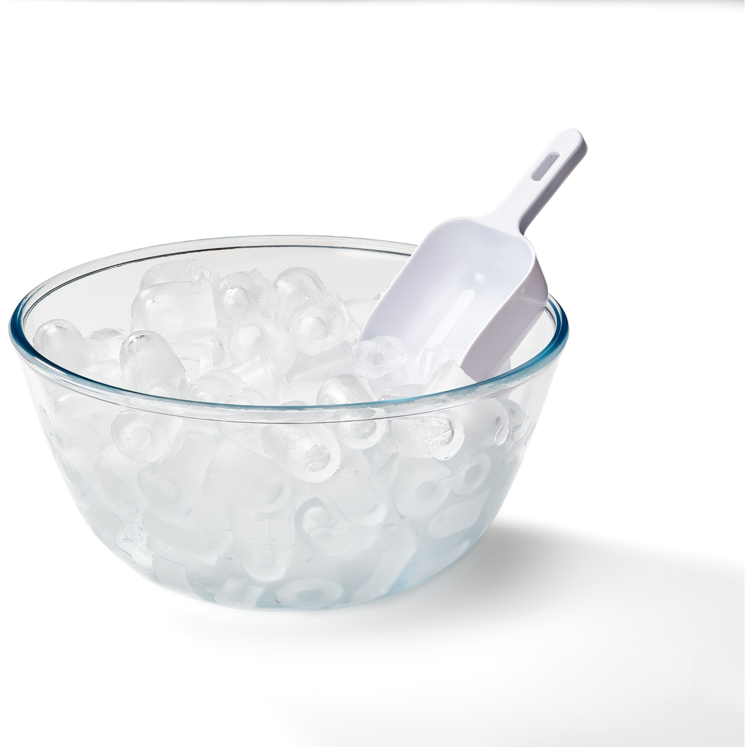 Een glazen kom vol ijsblokjes, met een witte schep erin.