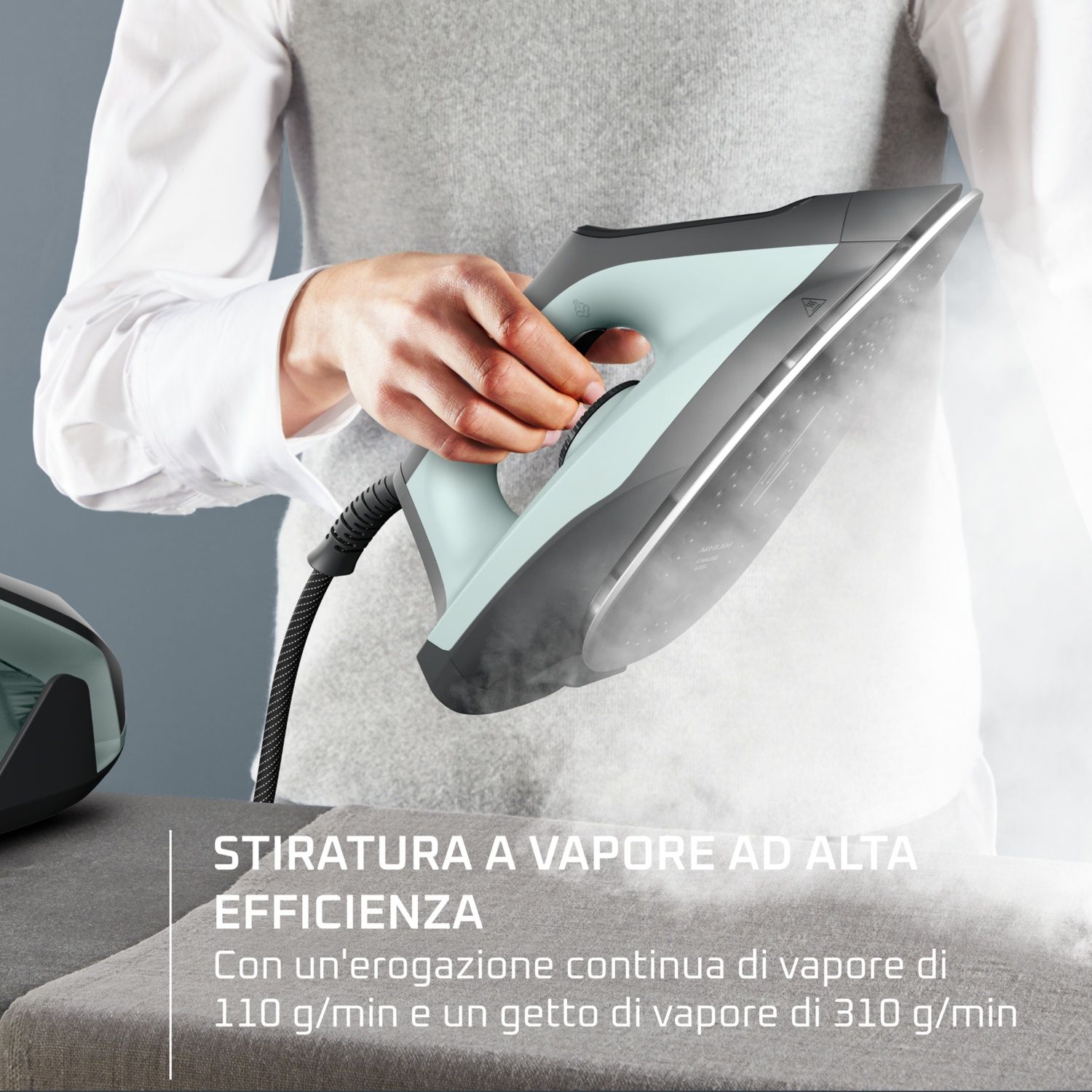 Persona che stira con ferro da stiro a vapore verde chiaro, vapore sale.
