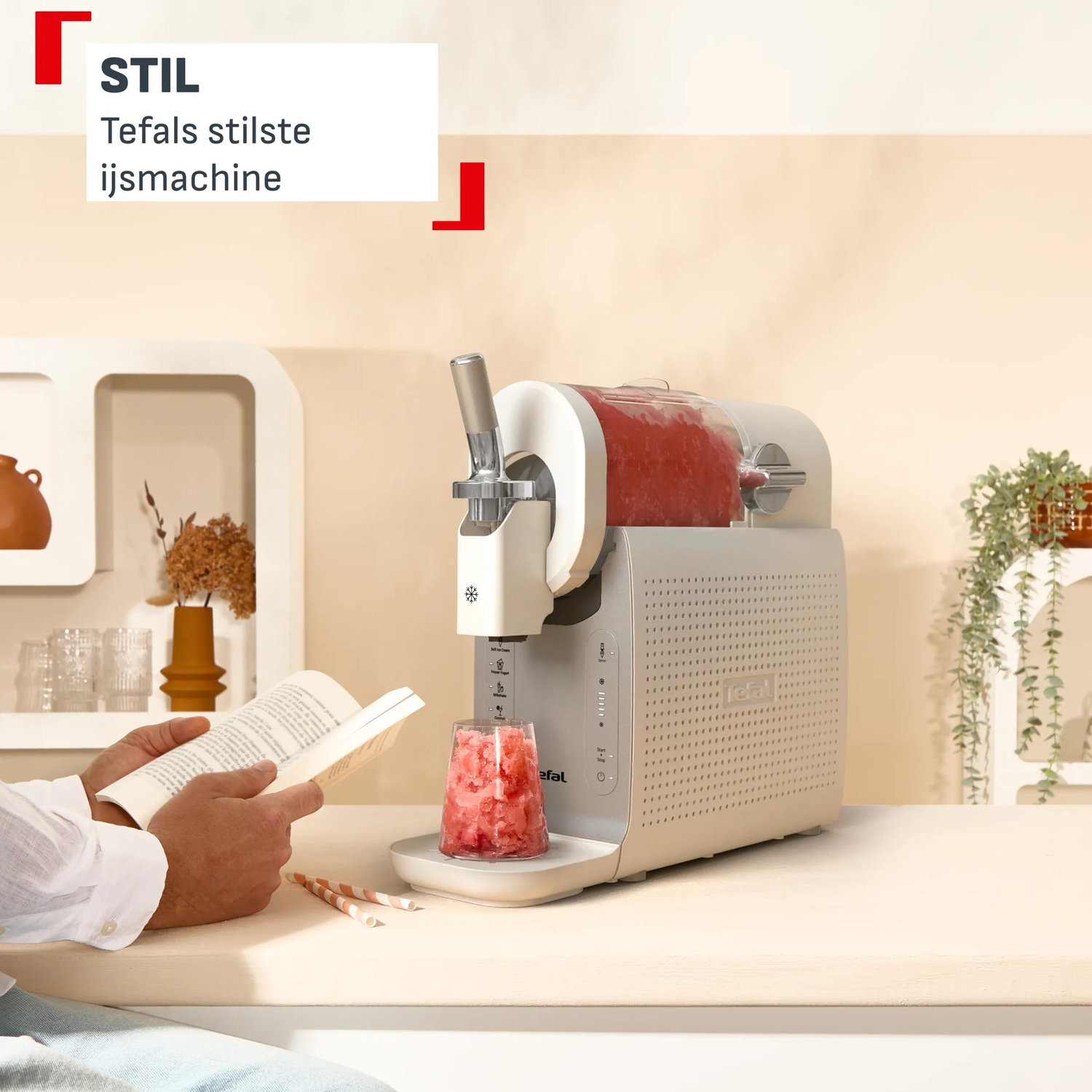 A person reads a book next to an ice cream maker with frozen fruit ice.