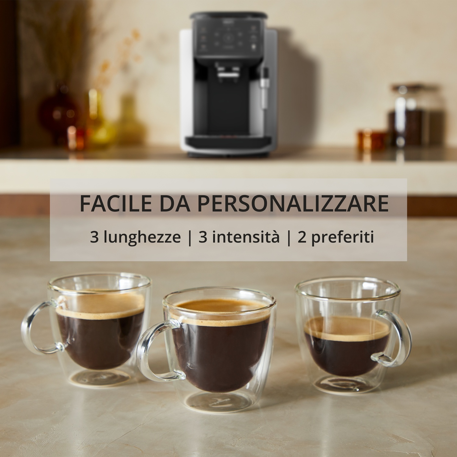 Macchina da caffè con tre tazzine espresso in vetro su tavolo marmo.
