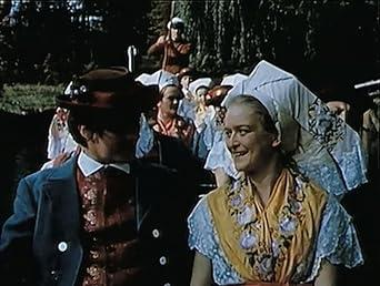 Ein Mann und eine Frau in traditioneller Kleidung lächeln sich an.