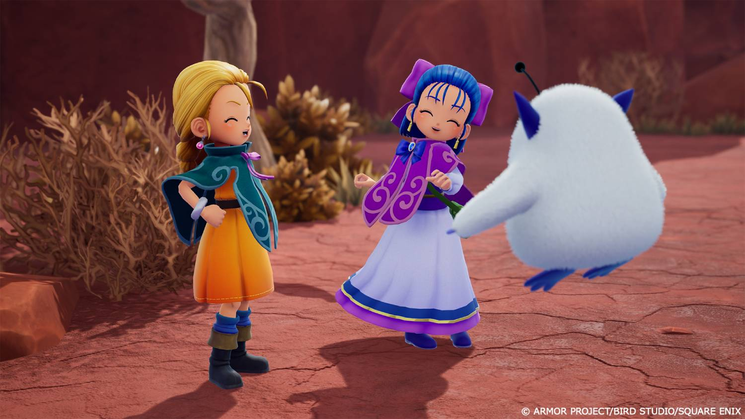 Tres personajes animados: dos chicas y una criatura blanca y esponjosa en un paisaje desértico.