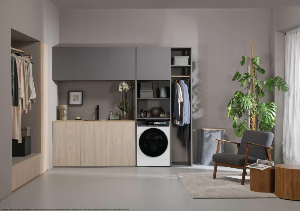 Ein moderner Waschraum mit Waschmaschine, Schrank und Sessel.
