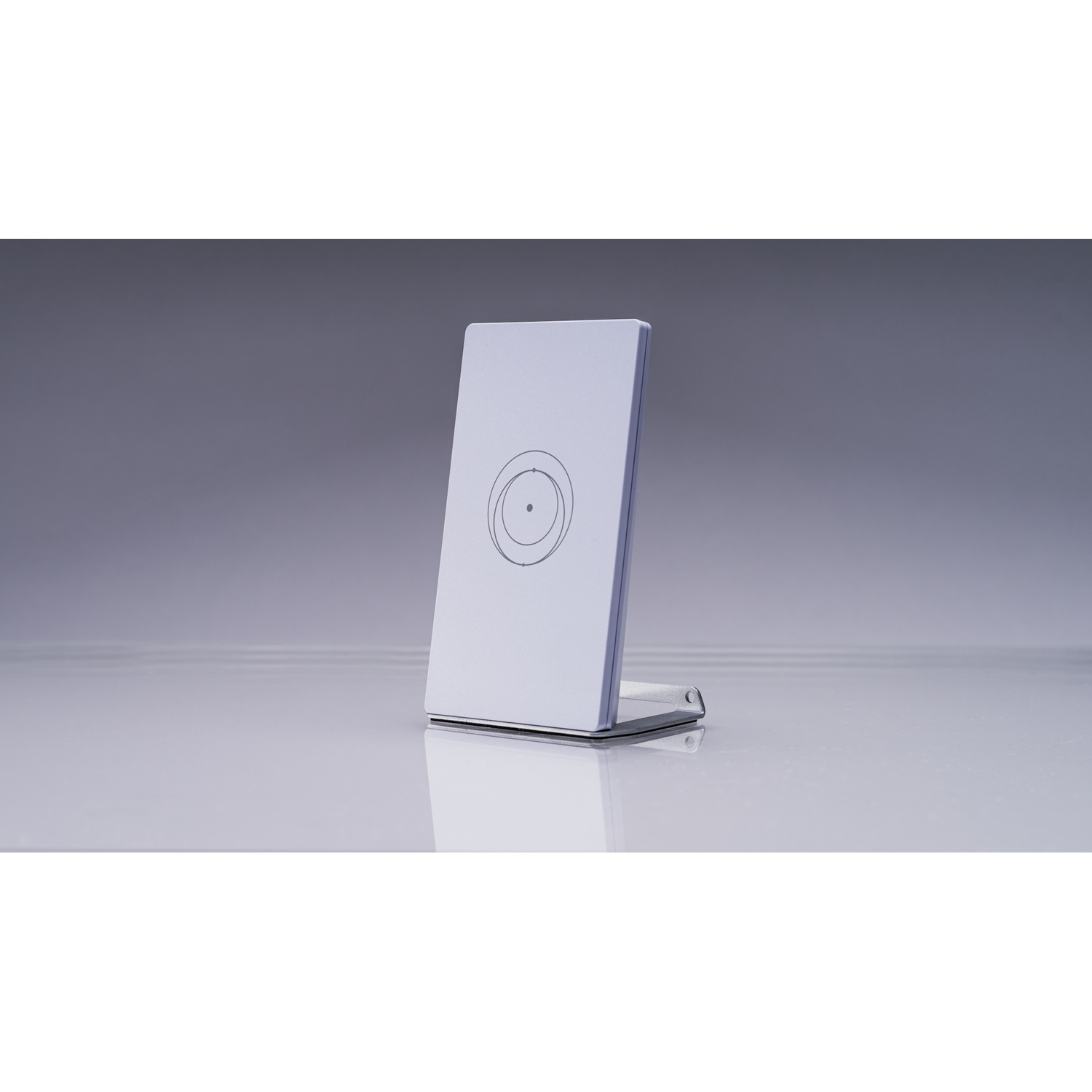 Un support blanc avec un motif circulaire repose sur une surface lisse.