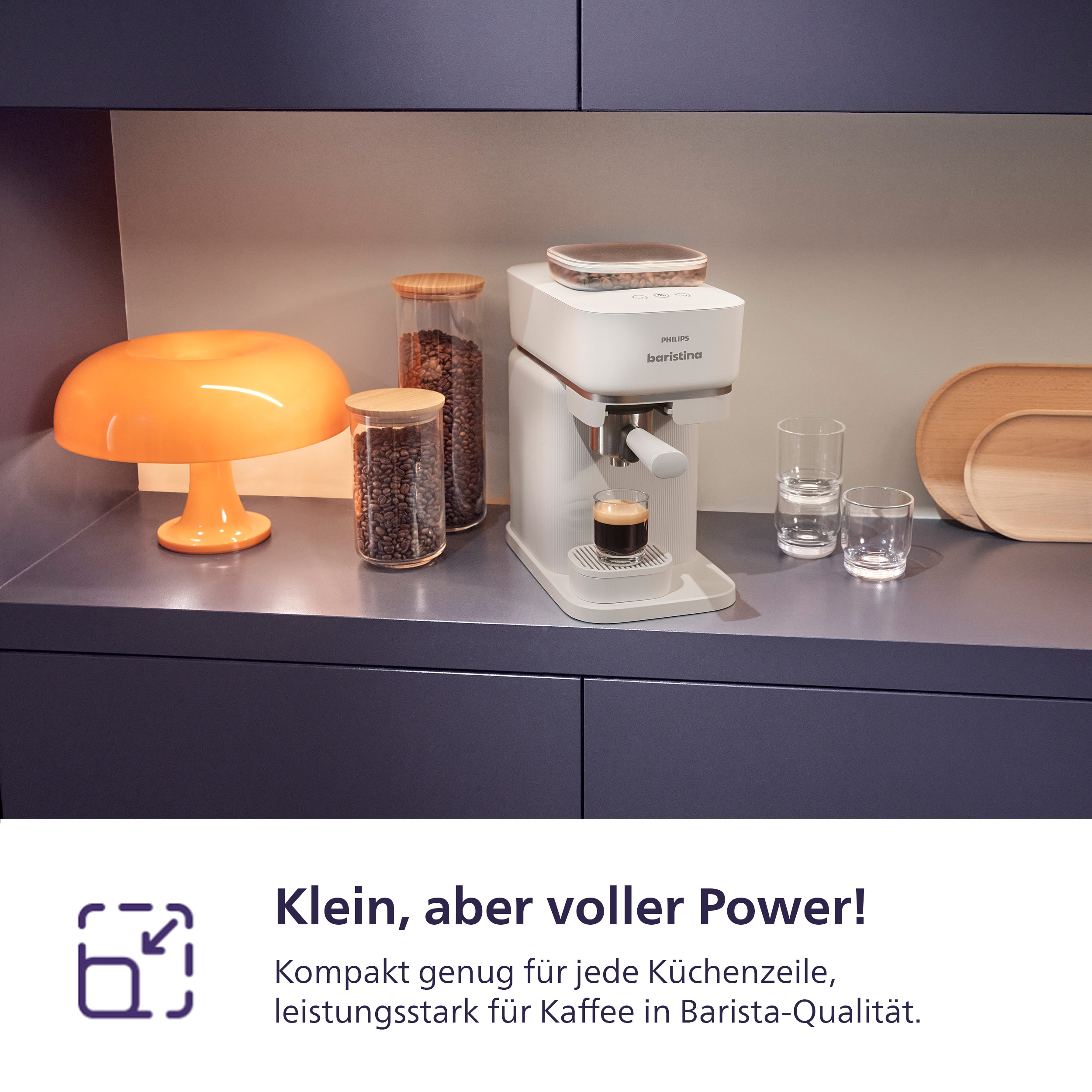 Eine weiße Espressomaschine mit Kaffeebohnengläsern, einer orangefarbenen Lampe und Holztabletts.