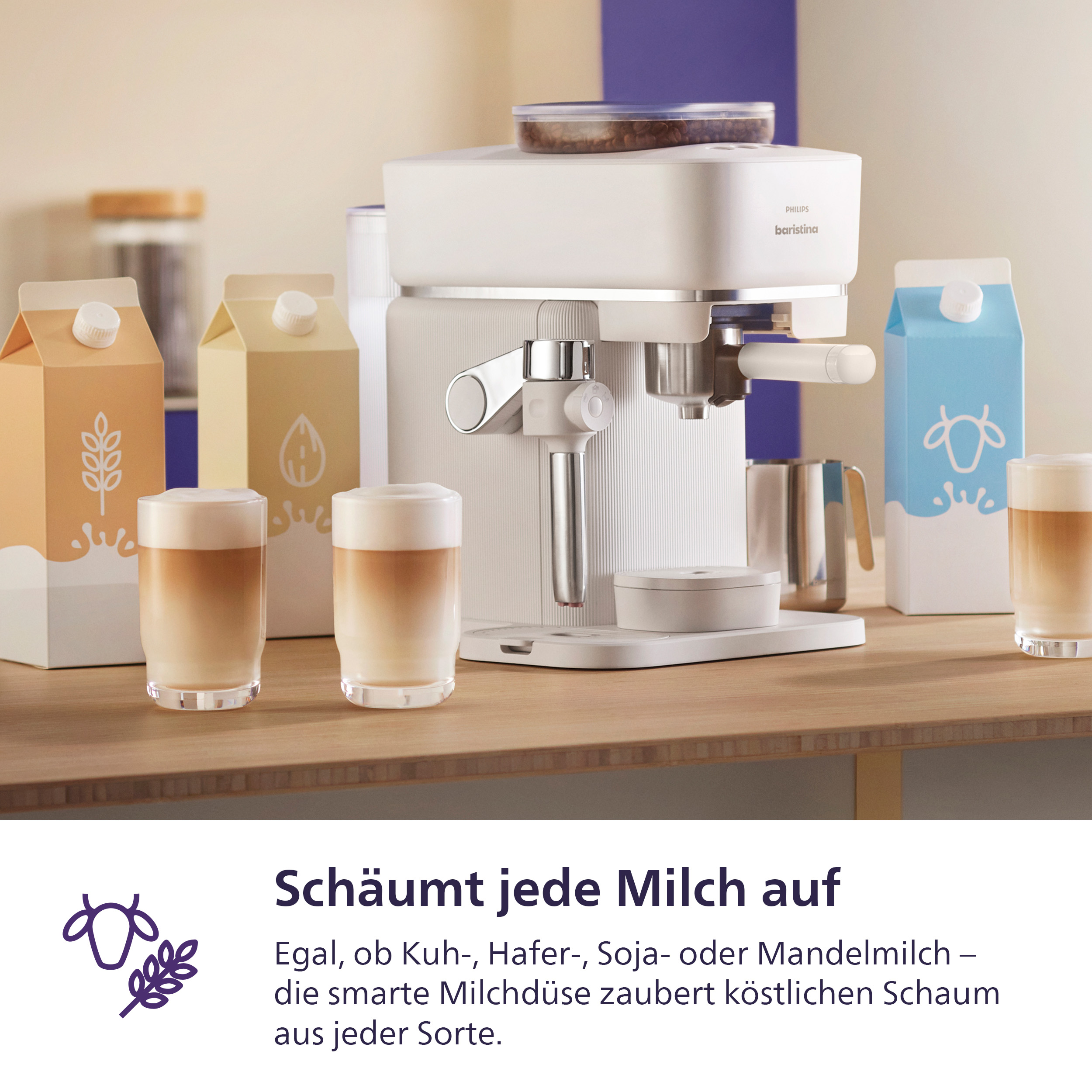 Eine weiße Kaffeemaschine mit Milchkännchen und Gläsern mit Kaffee.