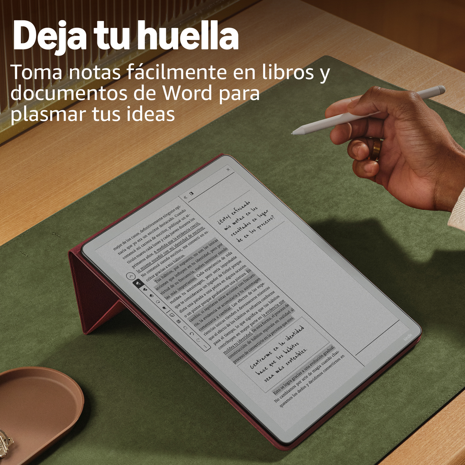 Una mano sostiene un lápiz sobre un e-reader posado sobre una alfombrilla verde.