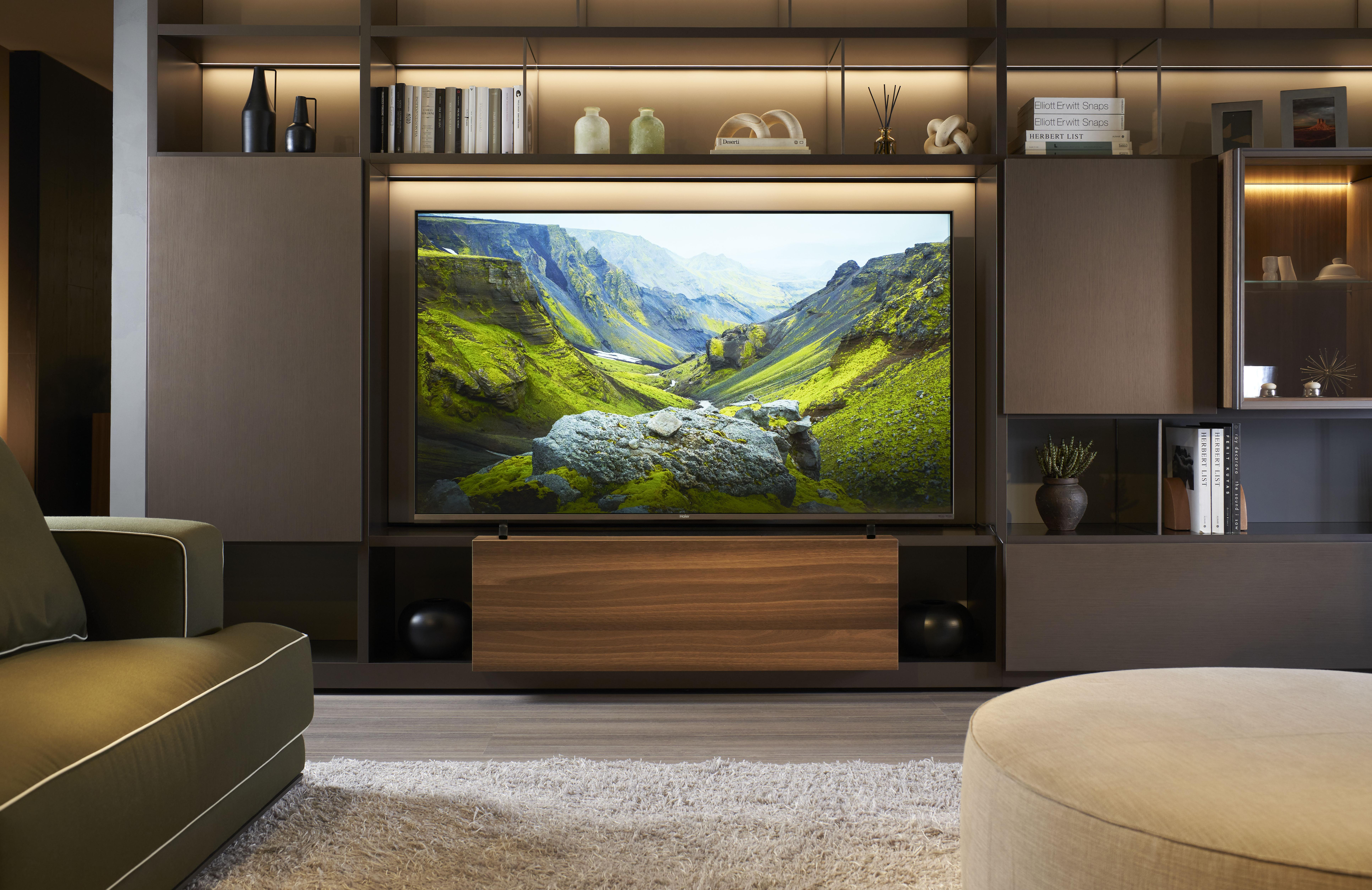 Una sala de estar con un televisor grande que muestra un paisaje verde.