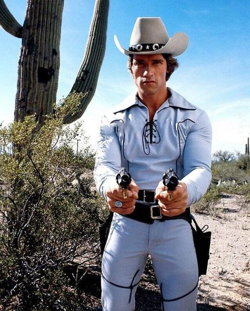 Ein Mann im Cowboyhut mit zwei Pistolen im Wüsten-Setting.