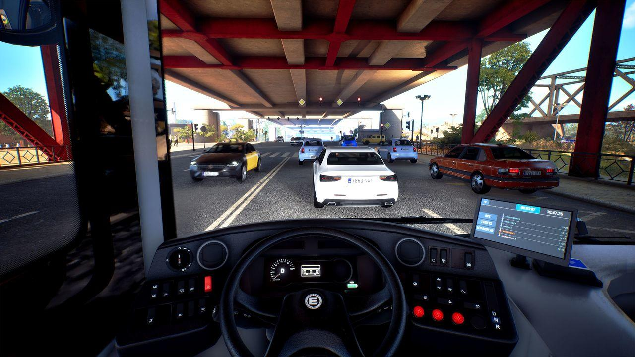 Innenansicht eines Busses, der unter einer Brücke fährt, mit Autos auf der Straße.