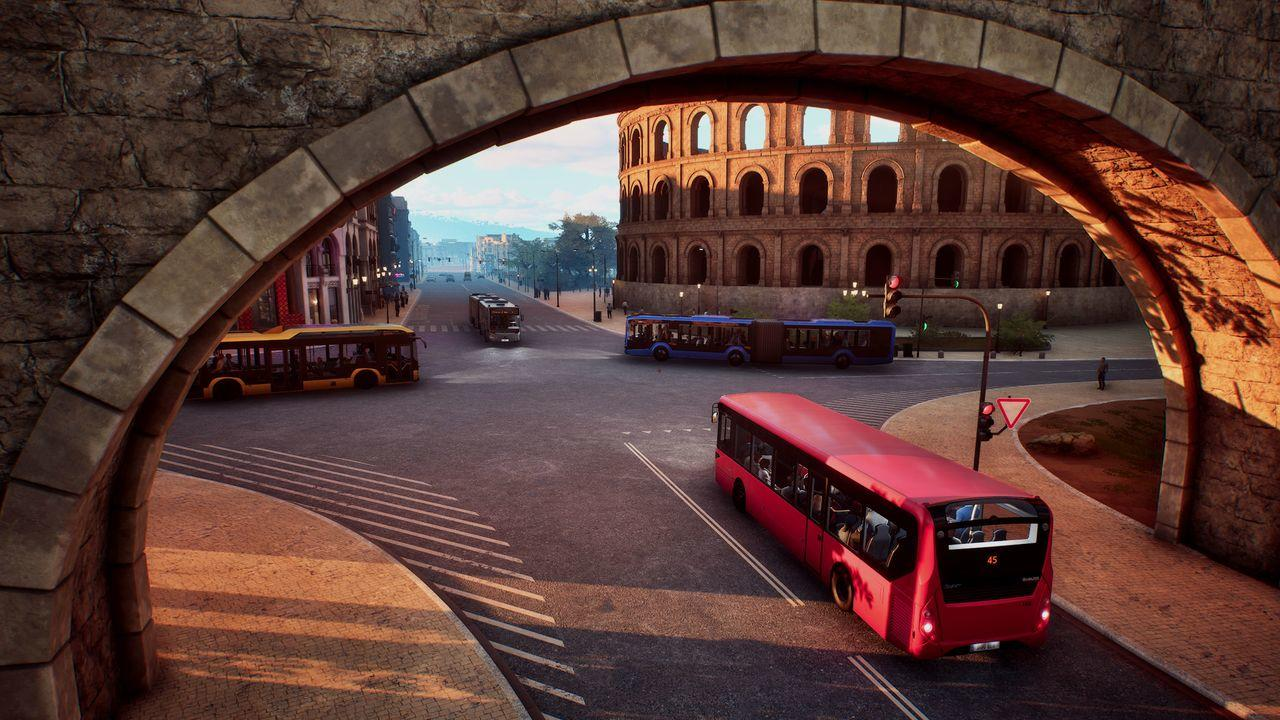 Ein roter Bus fährt auf einer Straße vor dem Kolosseum in Rom. Weitere Busse sind zu sehen.