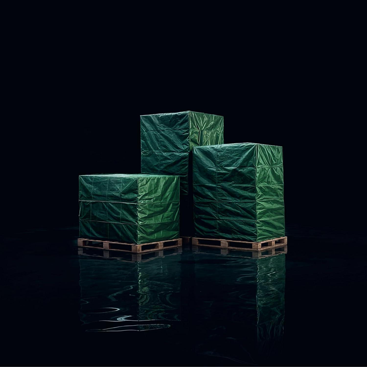 Drei grüne, in Folie verpackte Pakete auf Paletten im Wasser.