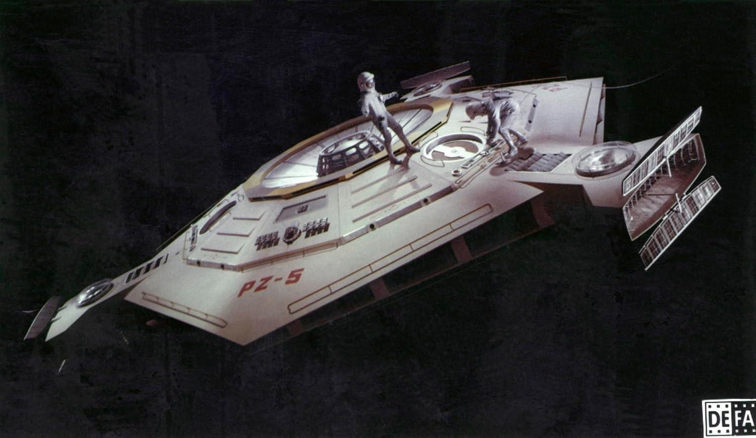 Zwei Astronauten auf einem weißen Raumschiff mit der Aufschrift "PZ-5".