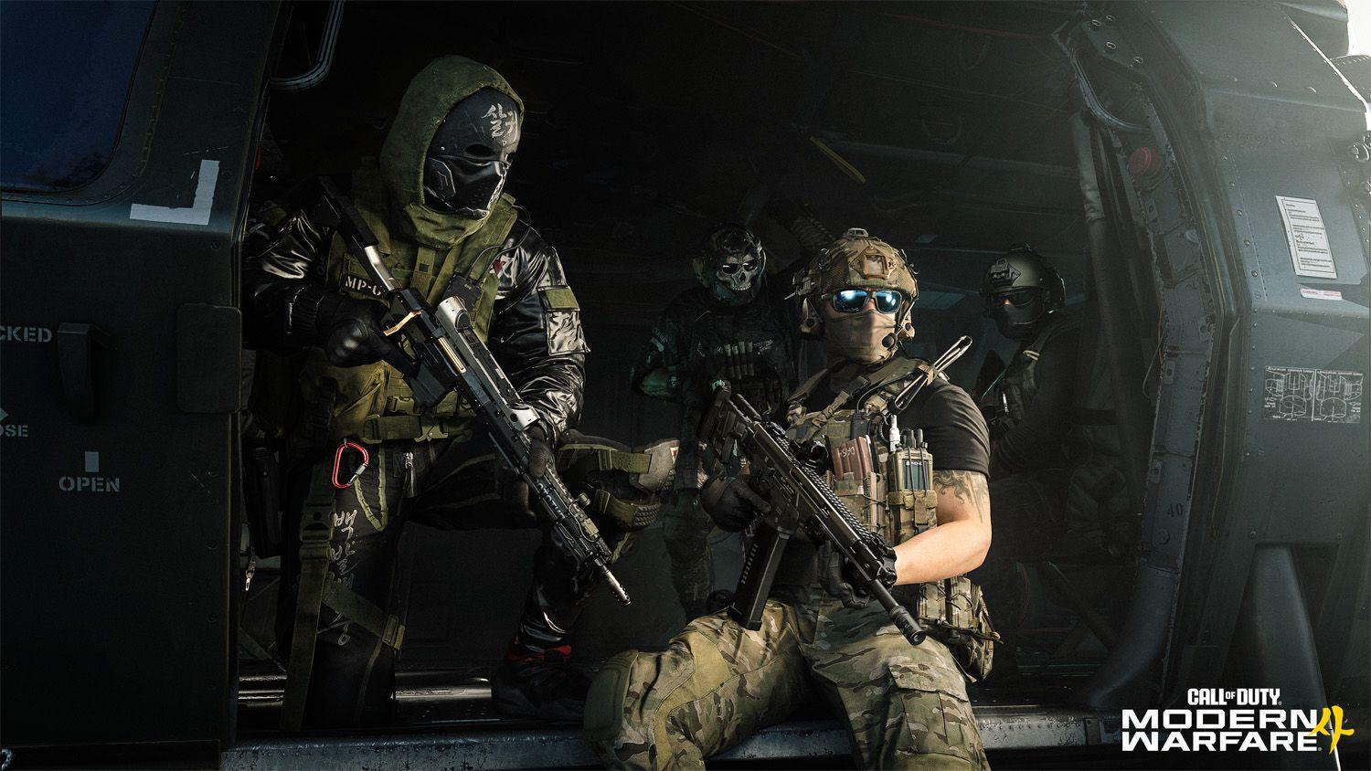 Soldaten mit Waffen stehen in einem Helikopter. Einer sitzt, andere stehen.