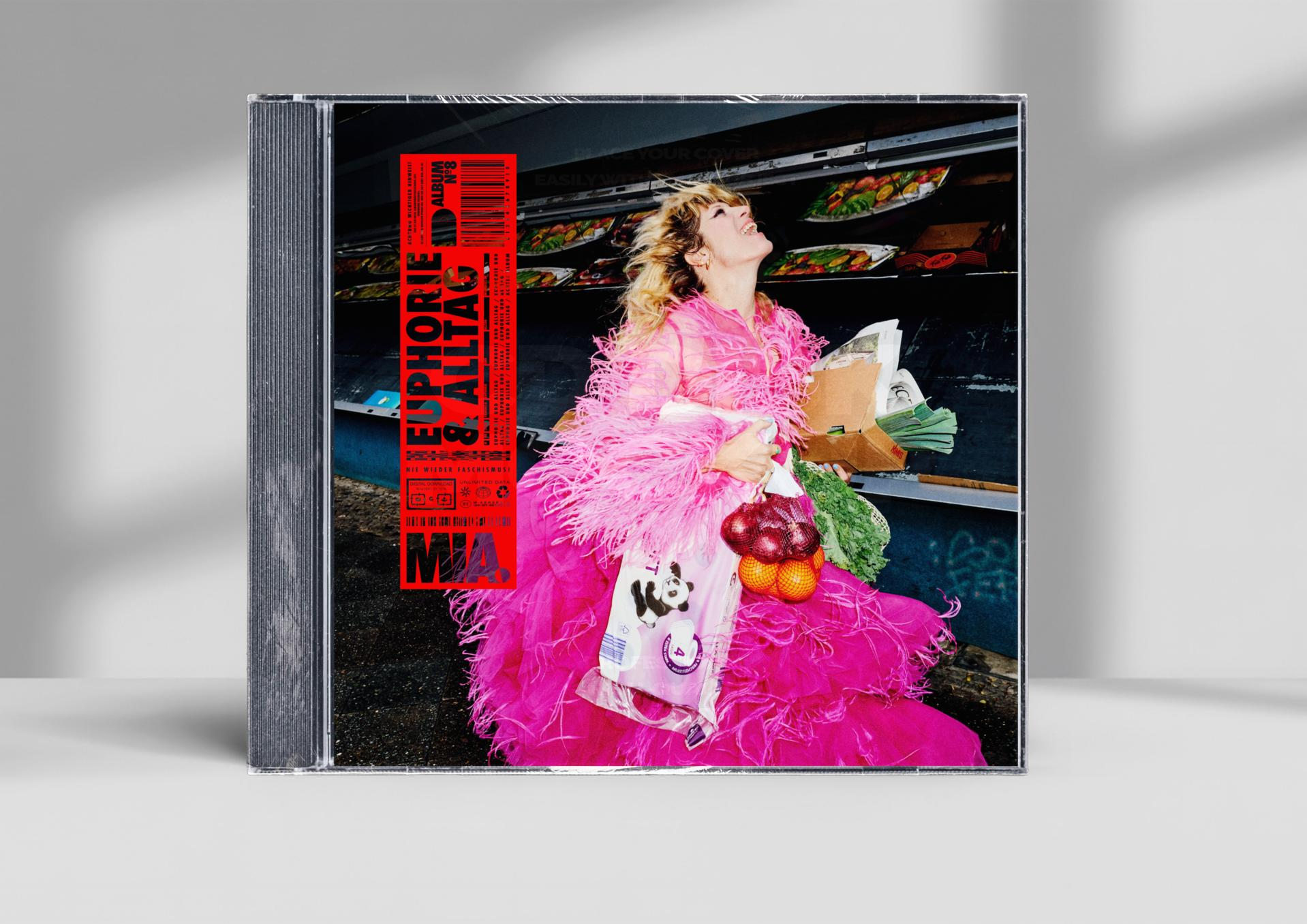 Eine Frau in einem pinken Federkleid hält Einkäufe vor einem CD-Cover mit dem Titel "Euphorie & Alltag".