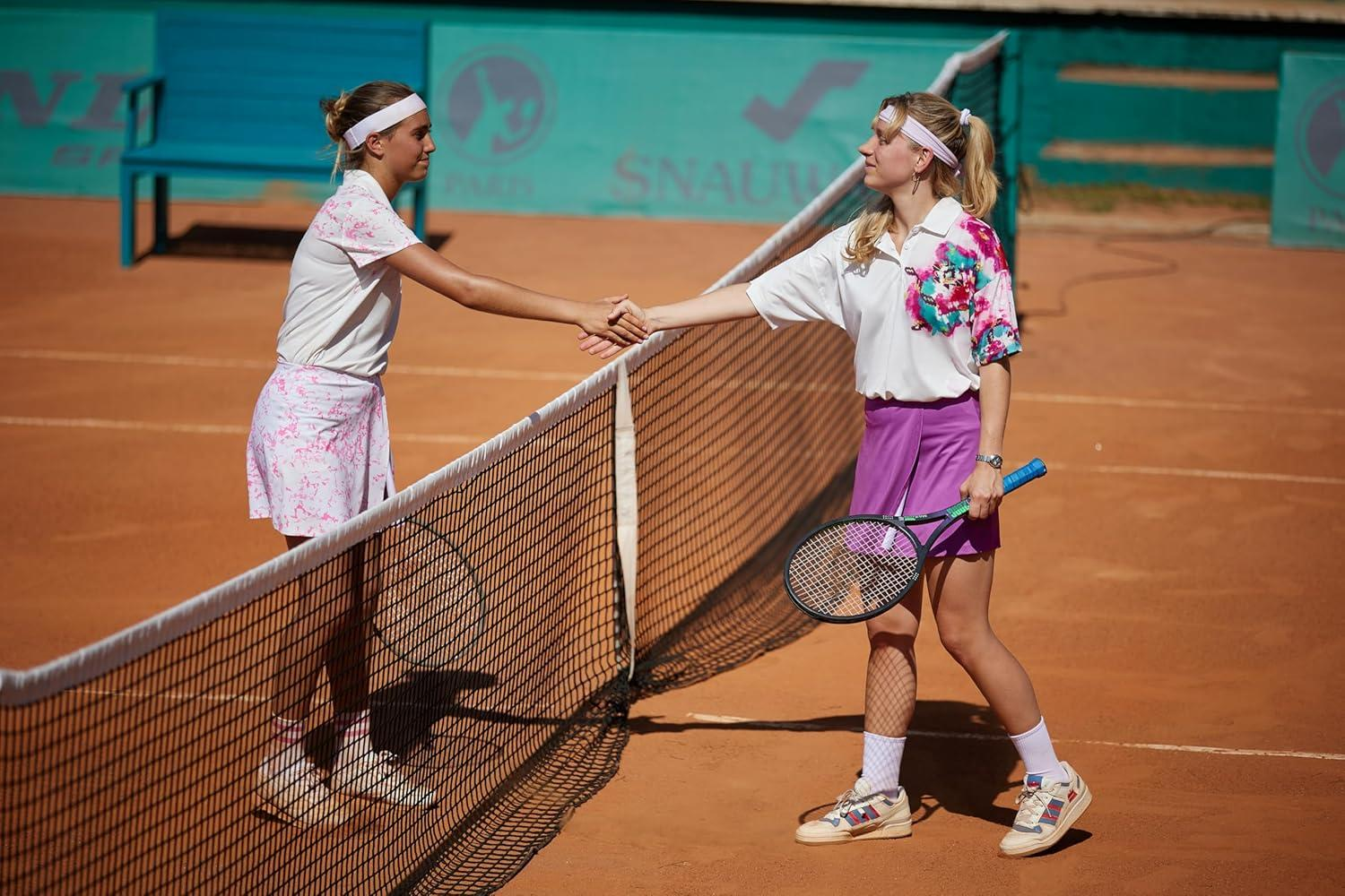 Zwei Tennisspielerinnen schütteln sich nach dem Spiel am Netz die Hände.