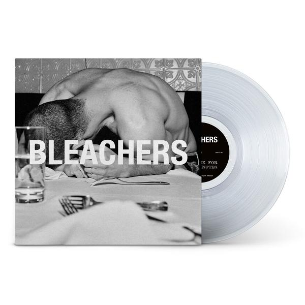 Ein Mann beugt sich über einen Tisch mit einer Vinyl-Schallplatte daneben.