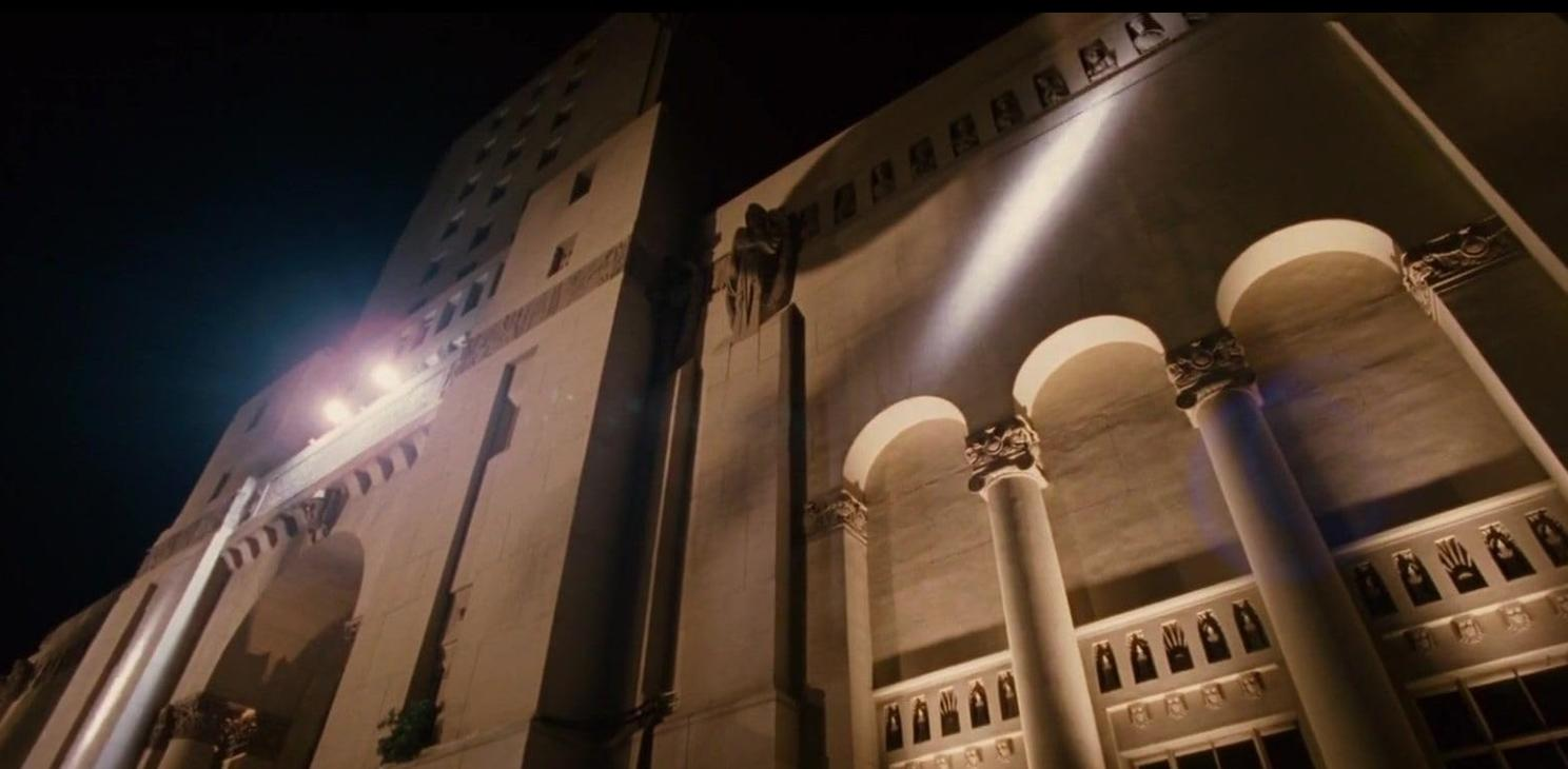 Ein großes, hell beleuchtetes Gebäude mit Säulen bei Nacht.