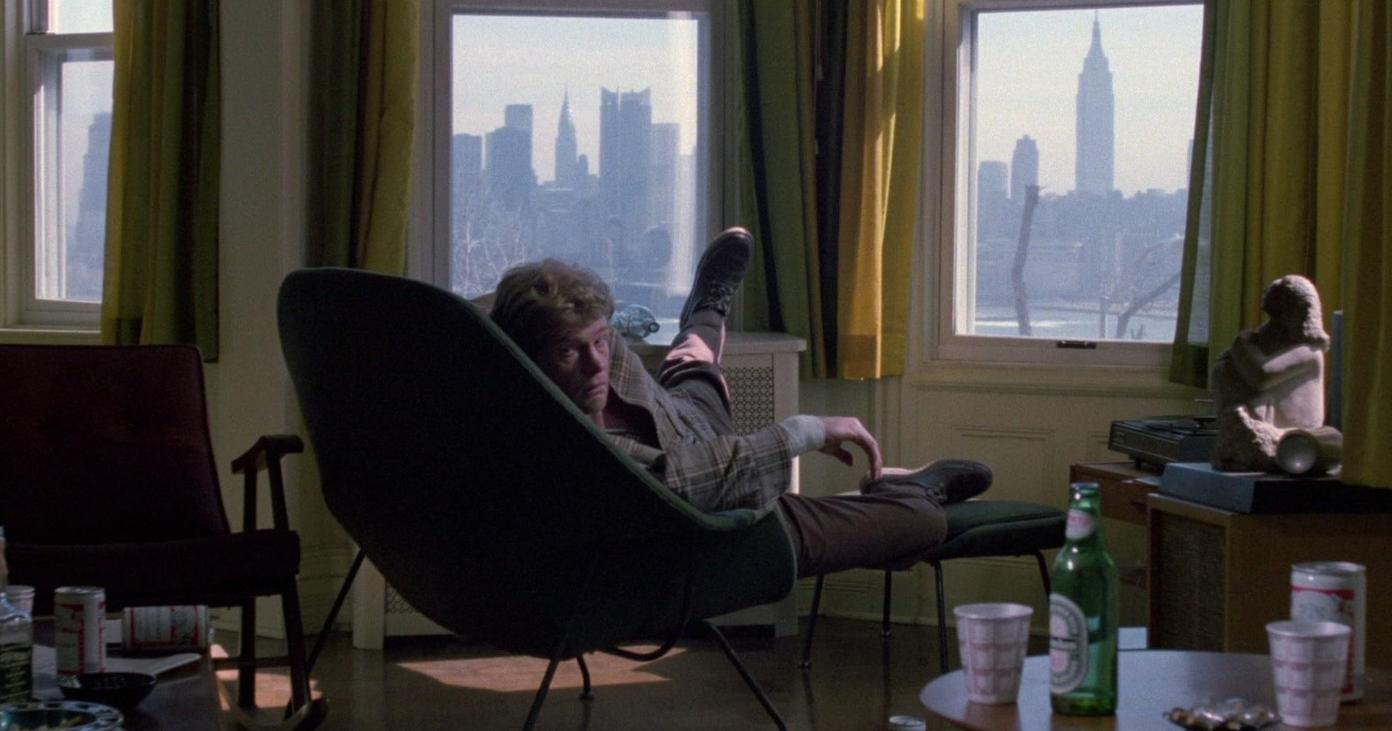 Mann liegt in einem Sessel, New Yorker Skyline im Hintergrund.