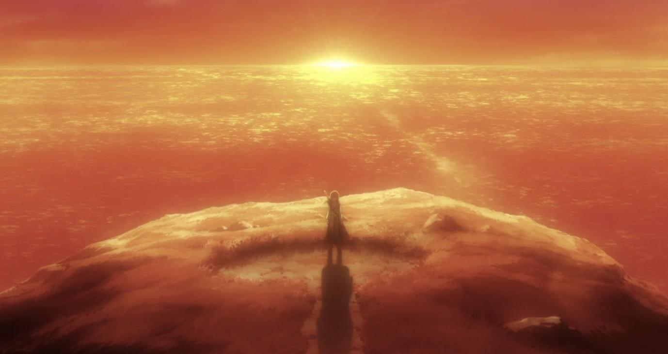 Eine Person steht auf einem Hügel am Meer bei Sonnenuntergang.