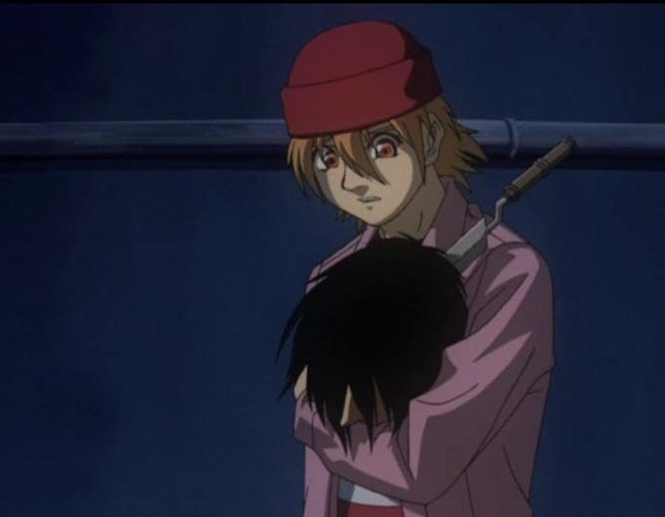 Anime-Charakter in rosa Hemd und roter Mütze umarmt jemanden im Dunkeln.
