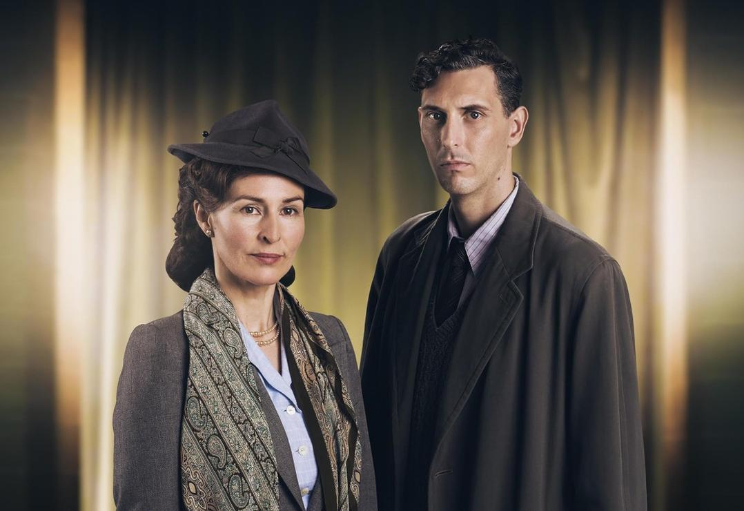 Eine Frau mit Hut und Schal neben einem Mann im Mantel.