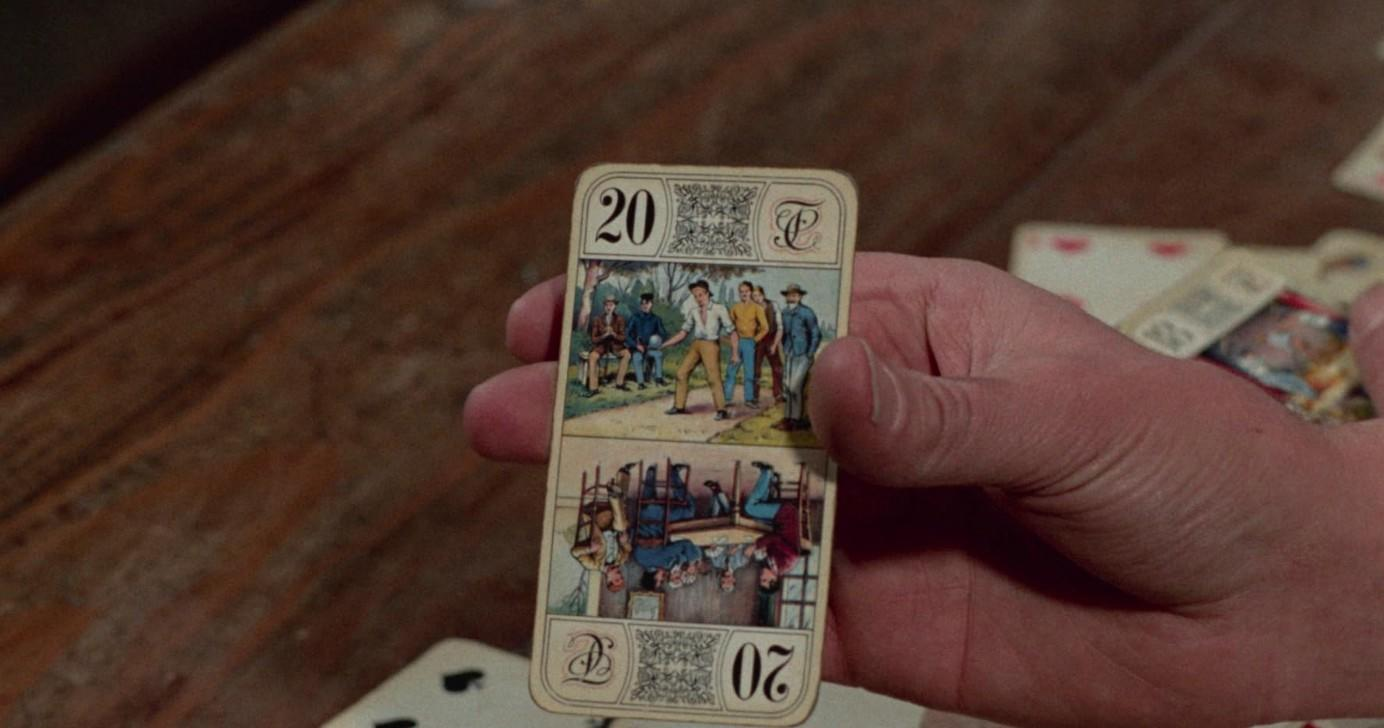 Eine Hand hält eine Spielkarte mit zwei Bildern und der Zahl 20.