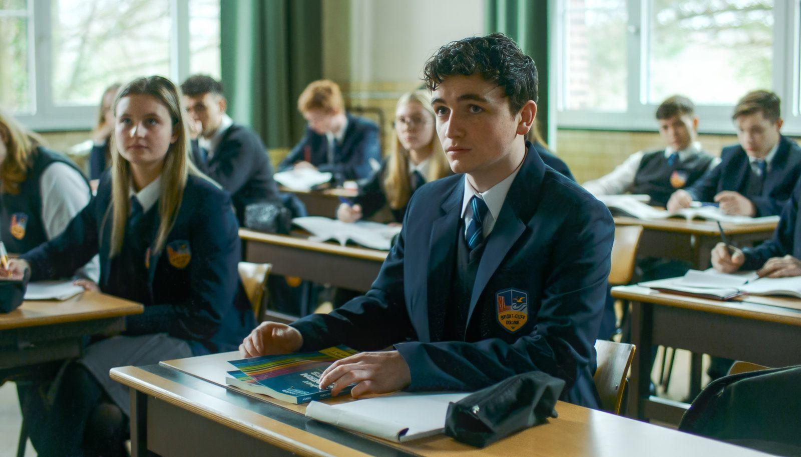 Schüler in Schuluniformen in einem Klassenzimmer, einige schauen nach vorne.
