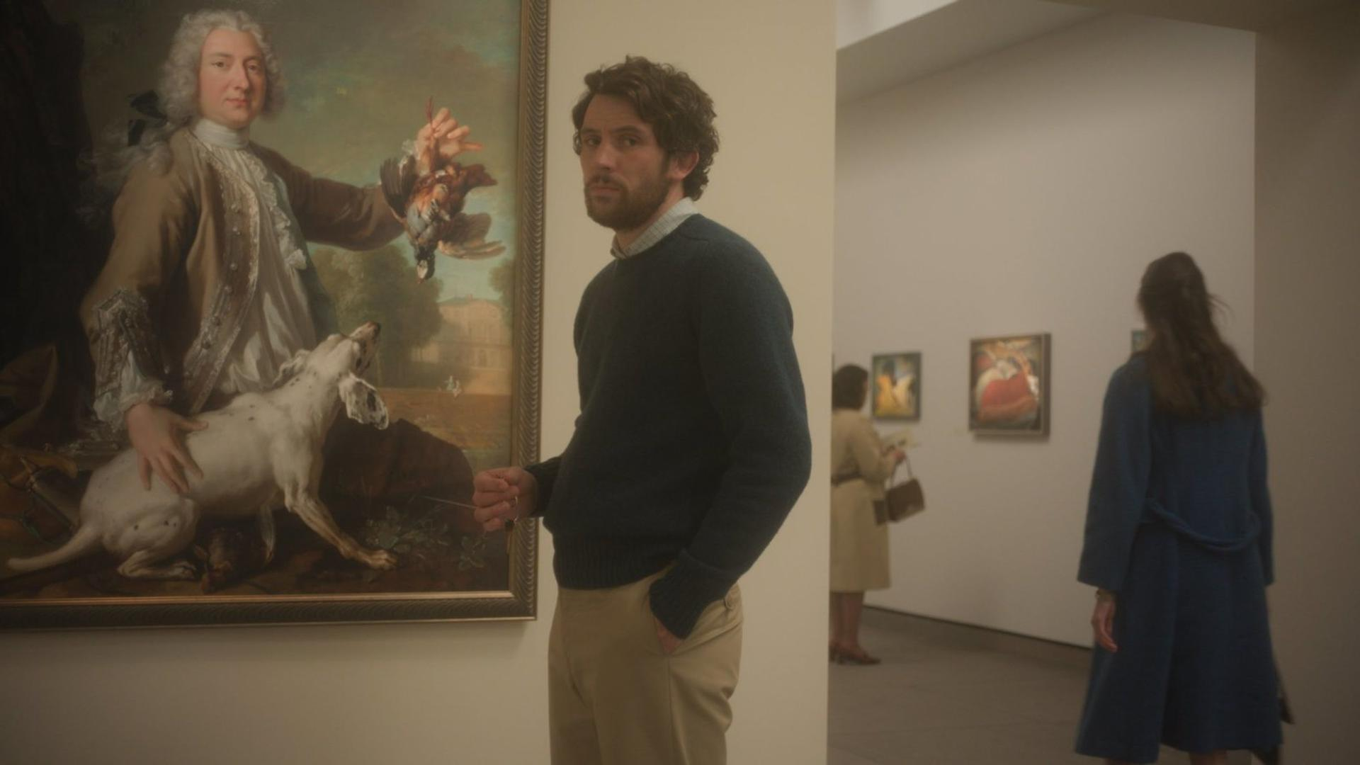Mann betrachtet Gemälde mit Mann, Hund und Vögeln in einer Galerie.