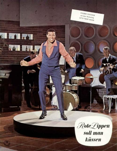 Chubby Checker mit Band auf einer Bühne. Ein Mann singt, andere spielen Instrumente.