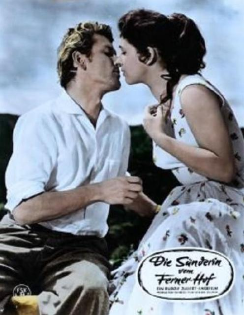Ein Mann und eine Frau küssen sich vor einem hellblauen Himmel.