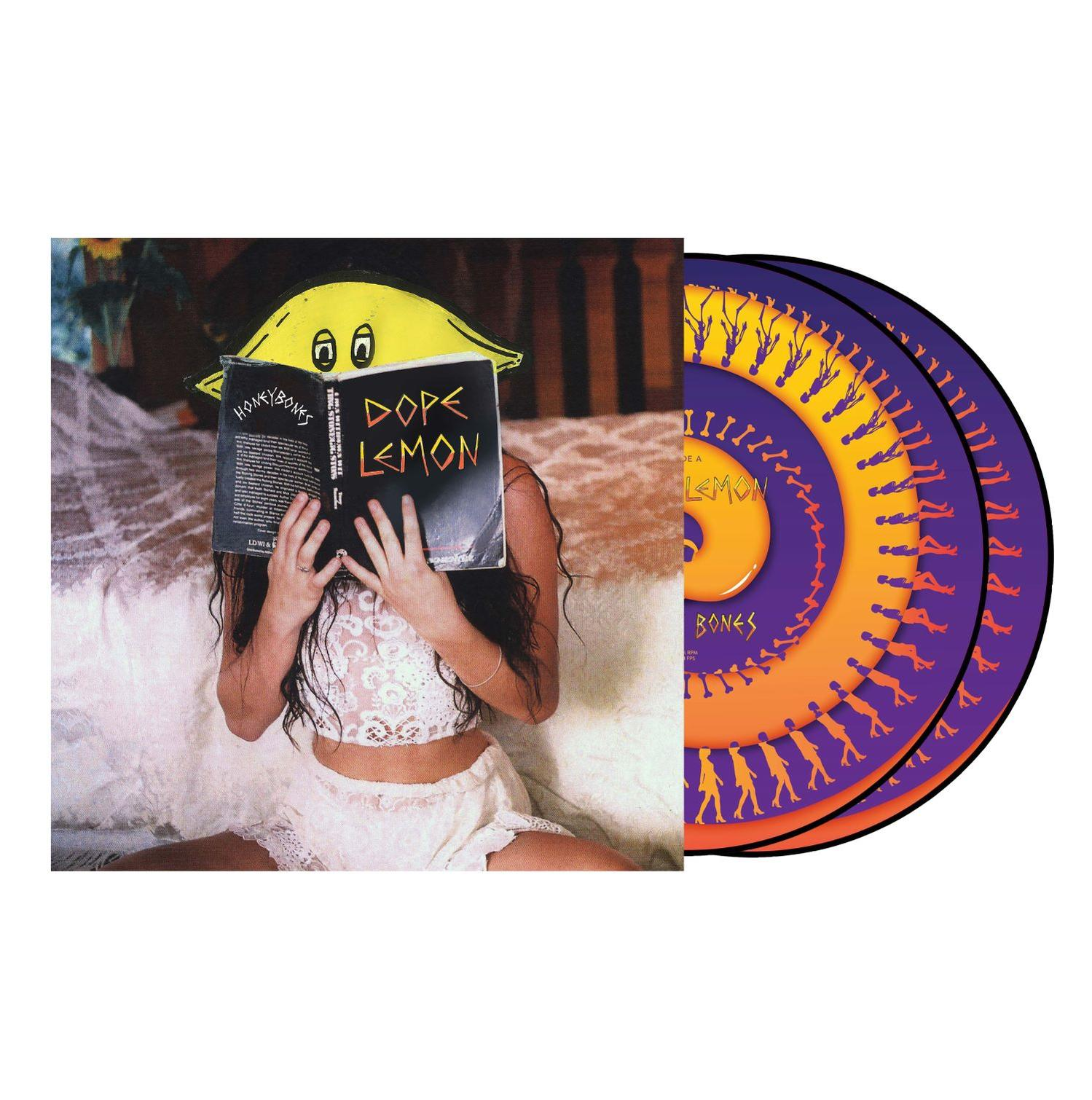 Eine Person liest ein Buch mit einem Zitronen-Cover, daneben Schallplatten.
