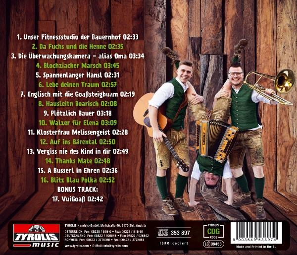 Drei Männer in Tracht machen Akrobatik vor Holzwand, einer spielt Gitarre, einer spielt Ziehharmonika, einer spielt Posaune.