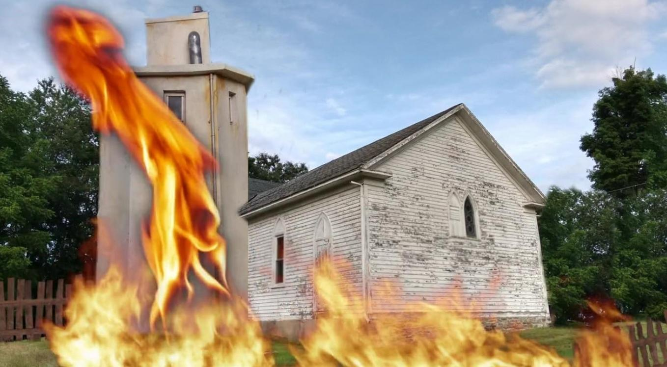 Kirche mit Glockenturm, umgeben von Flammen und Bäumen.