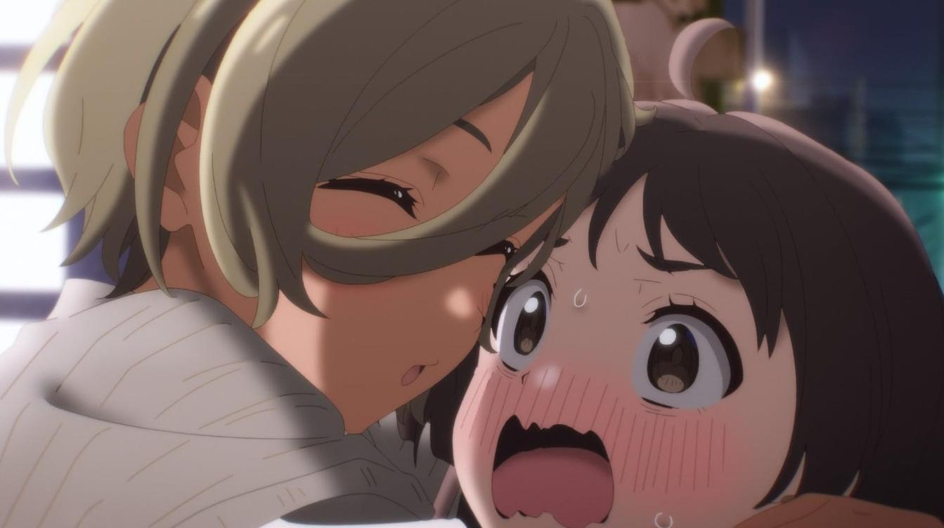 Zwei Anime-Mädchen umarmen sich. Eines lächelt, das andere sieht erschrocken aus.